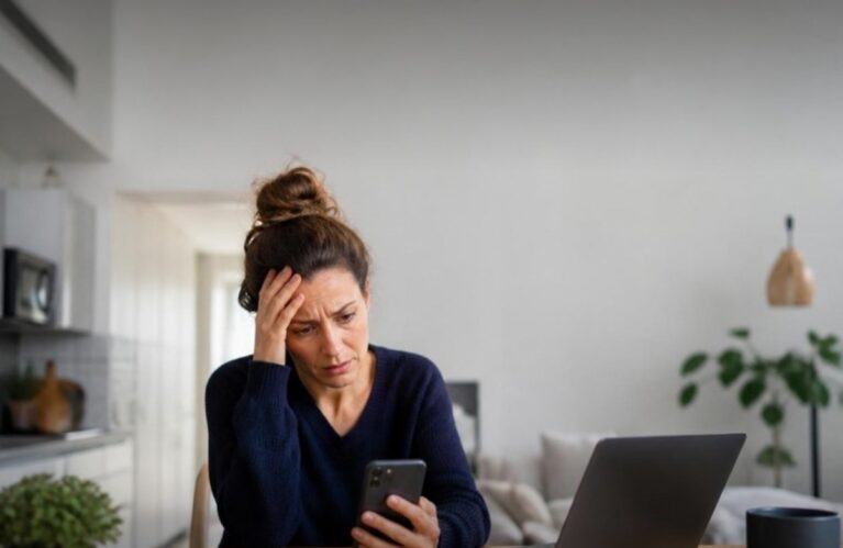Frustrated Airbnb host looking at her phone after Airbnb refunded a guest without her approval